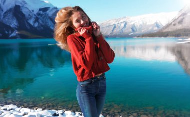 Güzel kadın sıcak kırmızı kazaklı Alaska'da yeni yıl kutluyor. Saf göl ve dağların arka plan üzerinde.