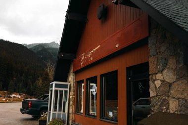 Vintage house köyün ortasında. Ahşap ve taş. Binanın telefon kulübesi yakınındaki kamyonet. Dağları çevresinde. 