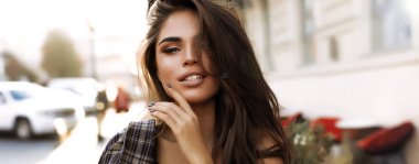 Yakın çekim yüz, doğal makyaj, beyaz dişler ve büyük dudaklar ihale cilt güzel genç bir bayanla portresi. Şık uzun saçlı. Açık moda çekim. Sonbahar sıcak ışık ve renkler. 