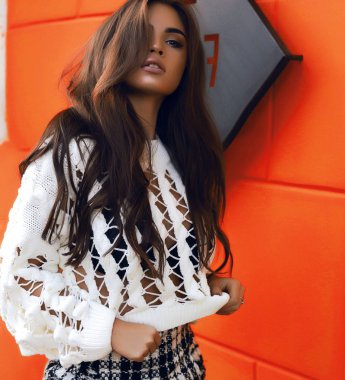 Beyaz gömlek ve Damalı etek seksi kız. Uzun şık saç ve güzel makyaj. Kafe duvar açık turuncu arka plan. Sıcak sarı ve kırmızı sonbahar renkleri. Modern moda giysiler.