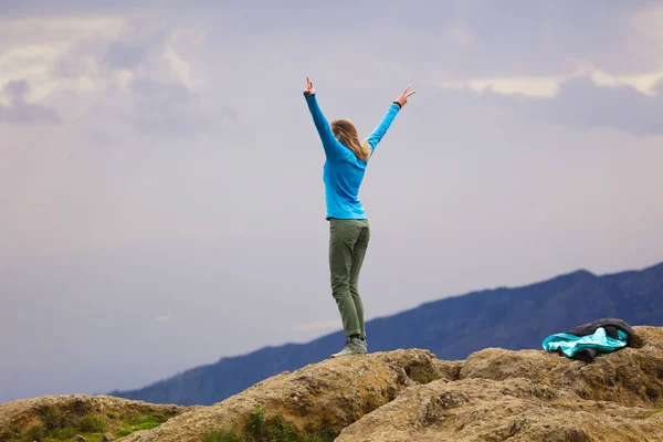 スリムなスポーツの女の子は キリマンジャロに登った 彼女は幸せと喜びの痛み 彼女の手を上げ 山と空からの美しい景色 青いジャケットとグレーのズボン極端な趣味 — ストック写真