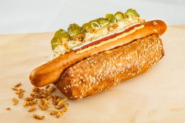 Kızarmış soğan ve salatalıklı klasik Alman sosislisi.