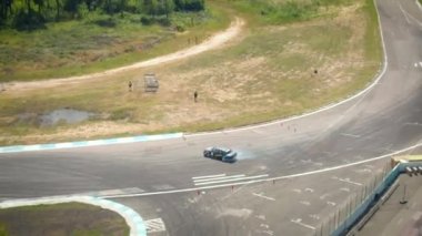 Sürüklenen araba, yarış pistinde sürüklenen profesyonel bir sürücünün uçan insansız hava aracı hız yolunda yanan lastiklerden çıkan dumanlı yarış arabası, 4K