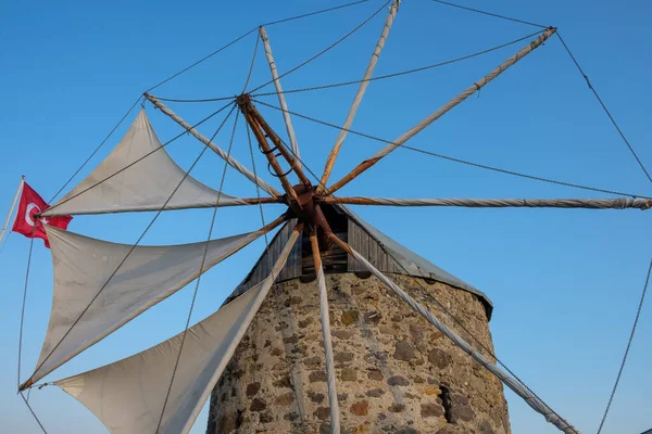 Antik taş yel değirmeni, mavi gökyüzü ve Türk bayrağı