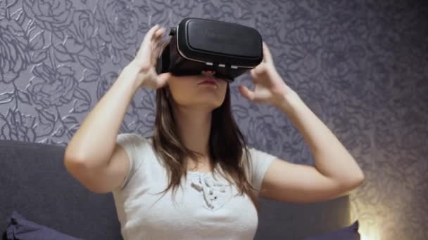 Mulher bonita vestindo fone de ouvido VR no quarto. Olhando em volta. Close-up assistir vídeo VR, jogar jogo VR . — Vídeo de Stock