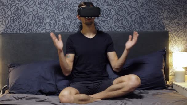 Man wearing VR Headset at bedroom. Doing yoga with glasses of virtual reality, meditates. — Stock Video