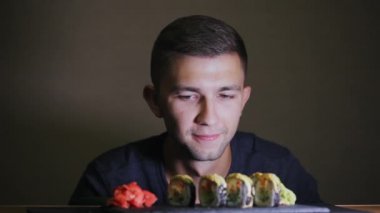 Aç bir adam suşi görünüyor, yemiyor, bekler