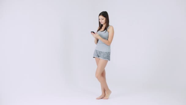 Le modèle Fit utilise le téléphone, l'application de remise en forme, le chat dans les vêtements de sport isolés sur fond blanc — Video