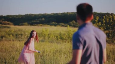 Mutlu çift frizbi şehir dışında bir güneşli yaz günü oynamak..