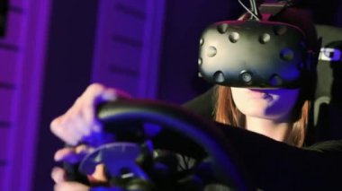 Modern sanal gerçeklik kulaklık kullanarak ve sürücü simülatörü Vr Club oynayan genç kadın. Video oyun kavramı