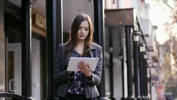 在日落时, 在商务酒店附近的街道上使用平板设备的美丽年轻女商人的肖像 — 图库视频影像