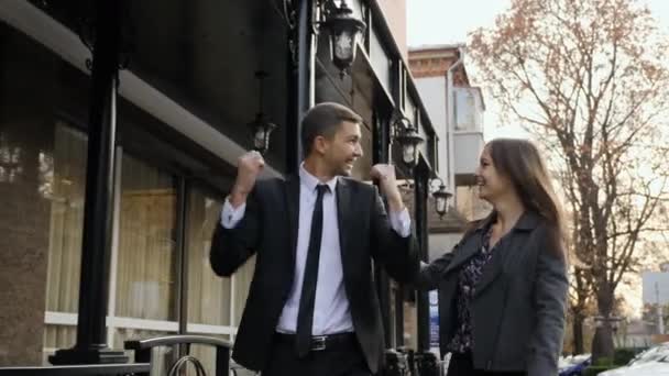 Collega's ondernemers gaan onderaan de straat, graag verhogen. Vrolijke Kaukasische man en vrouw die graag een succesvolle deal. Slow motion — Stockvideo