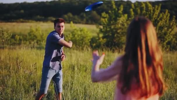 Lyckligt par spela frisbee bortrest på en solig sommardag. — Stockvideo