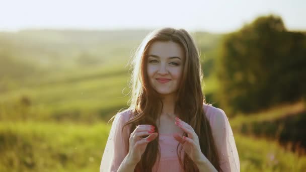 Retrato de mujeres hermosas mirando a la cámara, sonriendo y el viento moviendo su pelo, primer plano — Vídeo de stock