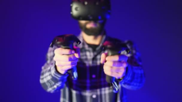 Γκρο πλαν, ελεγκτές από το Vr, πυροβολεί στο ένα shooter παιχνίδι εικονικής πραγματικότητας. Άνδρα που φοράει ακουστικό Vr σε μπλε φόντο — Αρχείο Βίντεο