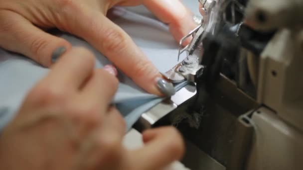 As mãos de mulheres cosem um overlock na máquina que cose. Overlock ponto na máquina de costura. Máquina de costura automática . — Vídeo de Stock