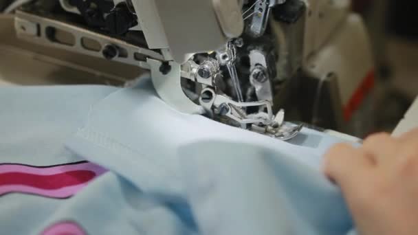As mãos de mulheres cosem um overlock na máquina que cose. Overlock ponto na máquina de costura. Máquina de costura automática . — Vídeo de Stock