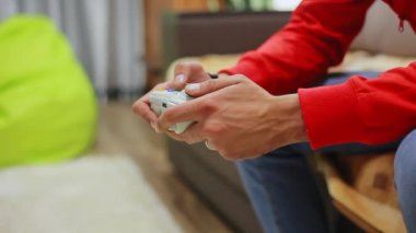 Evde video oyun oynayan adam. Oyun kumandasını kullanarak yakın çekim.