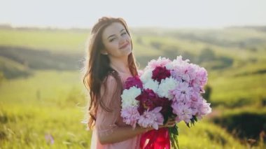 Çiçekler bir grup günbatımı Sniff buket üstünde belgili tanımlık tepe üzerinde tutan çekici kadın