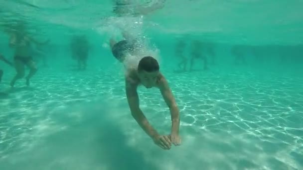 Un joven se zambulle en la piscina — Vídeos de Stock