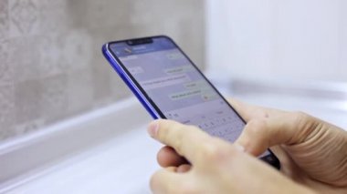 Dokunmatik ekran smartphone, metin yazarak holding yakın çekim erkek eller. Sosyal ağ uygulama iletisinde arkadaş cevap adam
