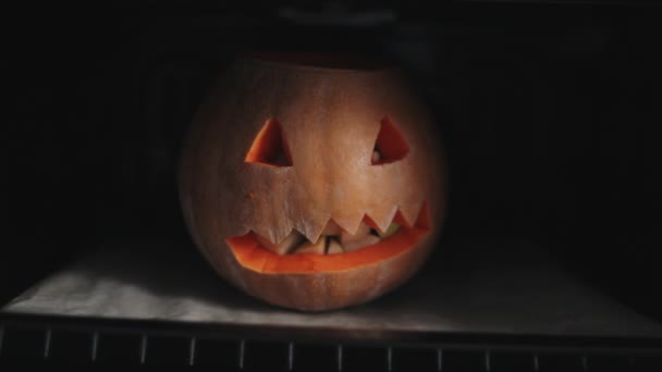 Der geschnitzte Kürbis an Halloween wird im Ofen gebacken, der mit Äpfeln gefüllt ist. Nahaufnahme — Stockvideo