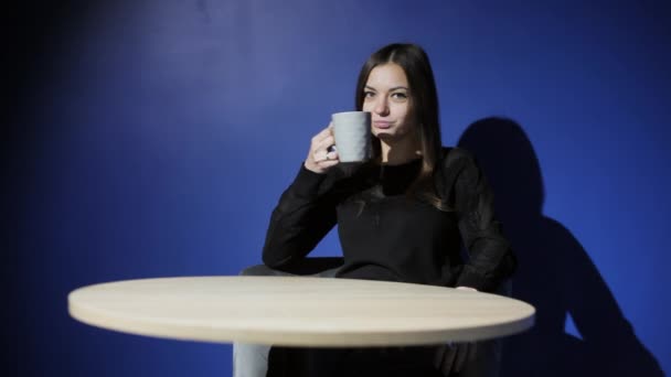 Молода жінка п'є каву в кафе . — стокове відео