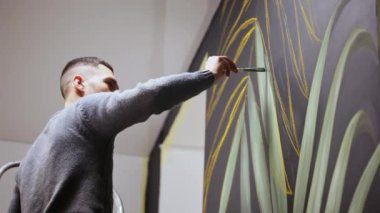 Duvara boya ile çizim grafiti sanatçısı. Erkek el fırça ile.