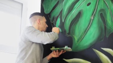 Duvara boya ile çizim grafiti sanatçısı. Erkek el fırça ile. Sanat kavramı.