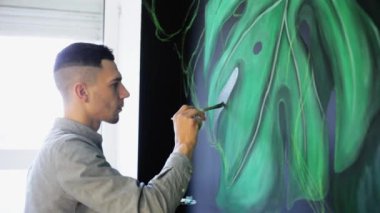 Grafiti sanatçısı çizim dalları üzerinde boya ile sallon içinde duvar.