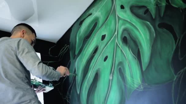 Graffiti artiste dessin avec de la peinture sur le mur sous le plafond. Main masculine avec pinceau. Concept d'art . — Video