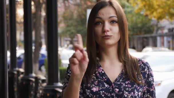 Ung kvinna säga nej genom att skaka huvudet och viftar sitt finger som kasserar gest, håller inte tecken. Känslomässiga ansikte uttryck. Närbild — Stockvideo
