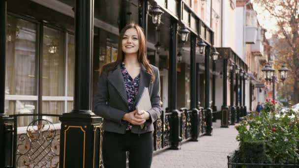 Porträtt av ung vacker affärskvinna tittar på kamera med leende utomhus, i händerna håller en tablett, Slowmotion — Stockvideo