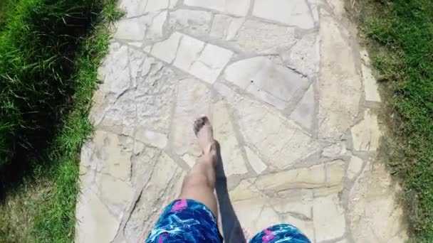 Člověk je chůze po kamenité cestě, v rámci nohy od shora dolů — Stock video
