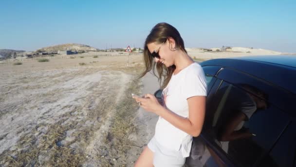 Jovem turista viajando de carro, use telefone, bate-papos com amigos na Internet — Vídeo de Stock