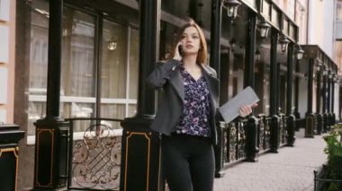 Güzel işkadını elinde, bir tablet ile telefonda konuşurken bir ofis binası çıkan onun taksi, rahatsız, ağır çekim için arıyor