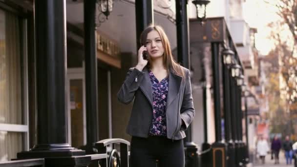 Aantrekkelijke Kaukasische zakenvrouw lopen op de straat op het kantoor gebouw achtergrond, praten over de telefoon. Emotionele spreken buitenshuis — Stockvideo