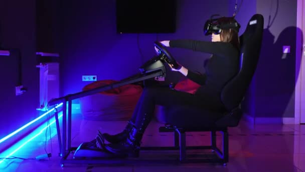 Mujer joven jugando en simulador de conducción de coche en el club VR, utilizando auriculares modernos de realidad virtual. Concepto de videojuego — Vídeo de stock