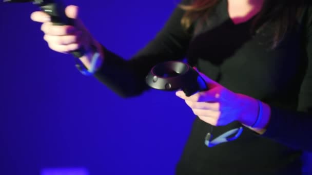 Close-up VR gamepad, controle remoto, mulher jogar jogo de vídeo interativo. Dois controladores de realidade virtual em fundo azul — Vídeo de Stock