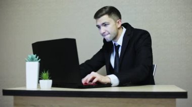İş yerinde bir bilgisayar oyunu oynamak genç iş adamı. Bir çalışan geri çalışırken oturur