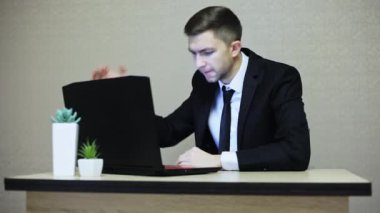 Dizüstü bilgisayarda çığlık ve gesticulating öfkeli işadamı