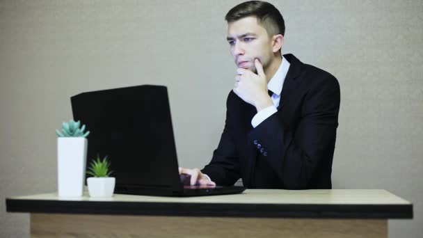 Knappe zakenman werken op kantoor, typen op een laptop. — Stockvideo