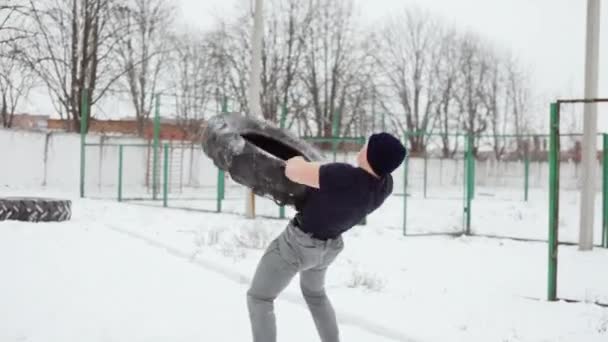 Powerlifter lancia un pneumatico di gomma su se stesso, l'uomo che fa esercizi di crossfit in inverno — Video Stock