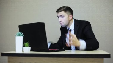 Dizüstü bilgisayarda çığlık ve gesticulating öfkeli işadamı