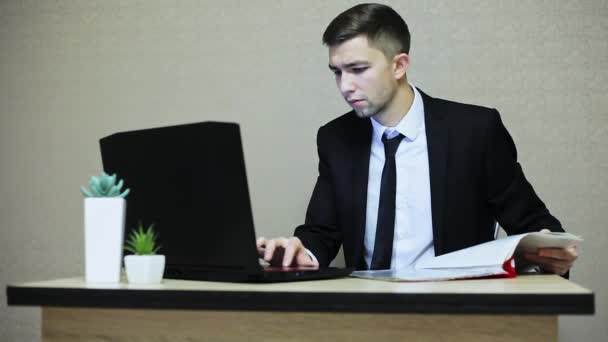 Jovem empresário trabalhando no escritório, digitando em um laptop . — Vídeo de Stock