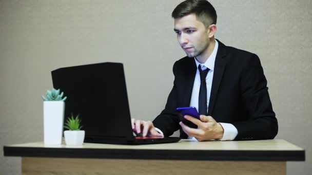 Bello uomo d'affari che lavora in ufficio, digitando su un computer portatile . — Video Stock