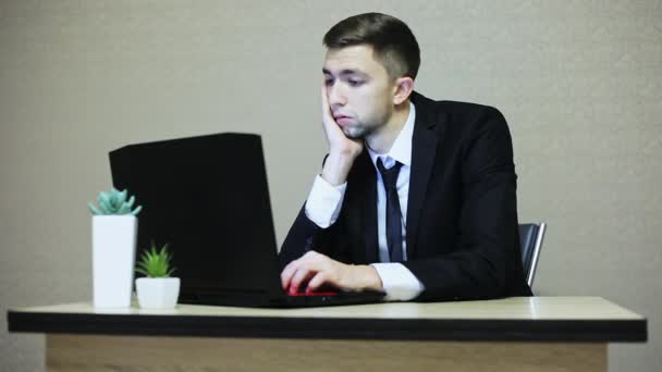 Gelangweilter Geschäftsmann im Anzug arbeitet am Laptop — Stockvideo