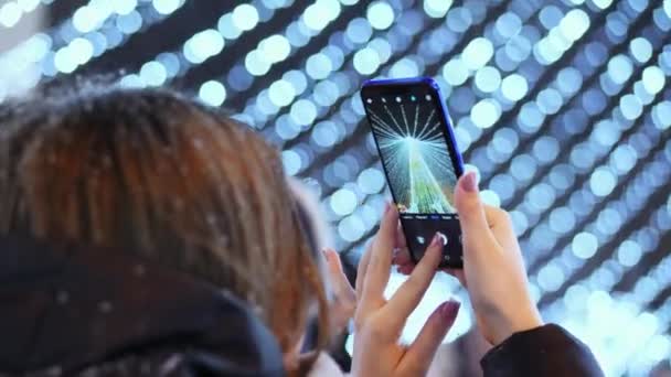 Женские фотографии на телефоне главный город Рождественская елка на новогодние праздники — стоковое видео