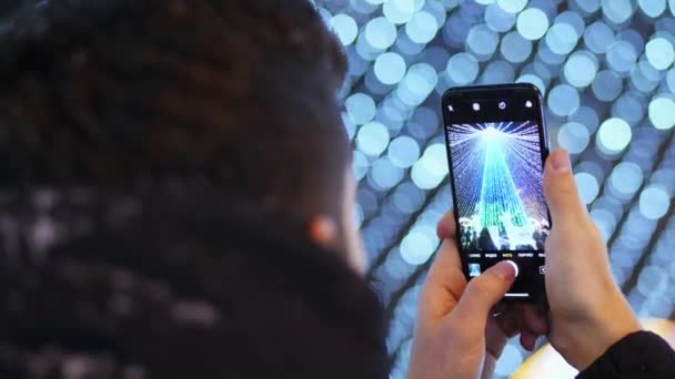 Hombre tomar una foto en el teléfono en el árbol de Navidad de la ciudad principal en las celebraciones de Navidad — Vídeo de stock