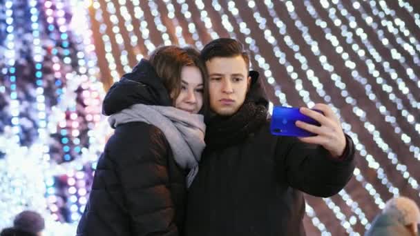 Magnifique homme et femme fait un selfie au téléphone, souriant dans la nuit du Nouvel An — Video